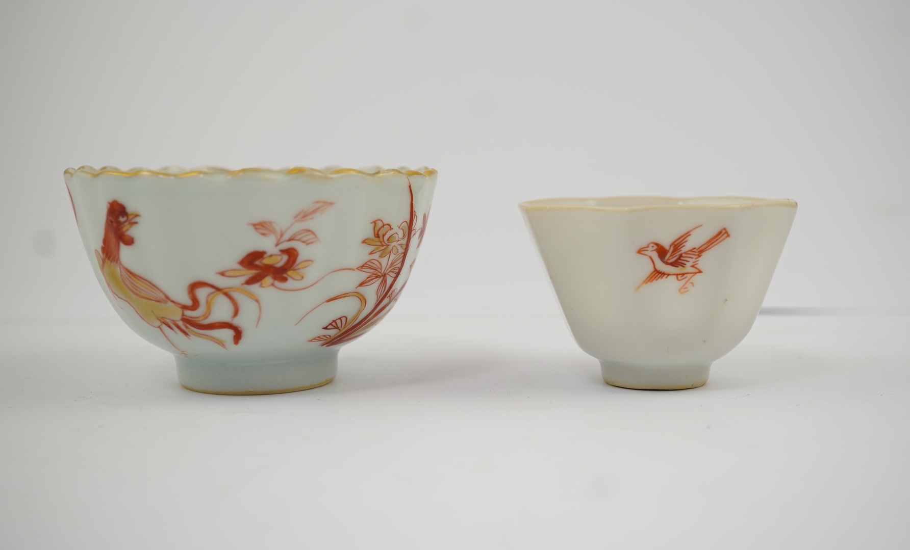 A Chinese rouge de fer tea bowl and saucer and a similar cup, Qianlong period